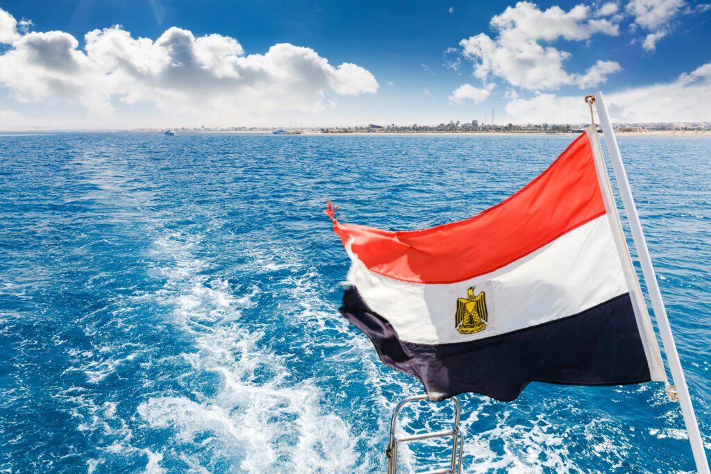 A vibrant Egyptian flag on a boat with clear blue water in Hurghada, Egypt.